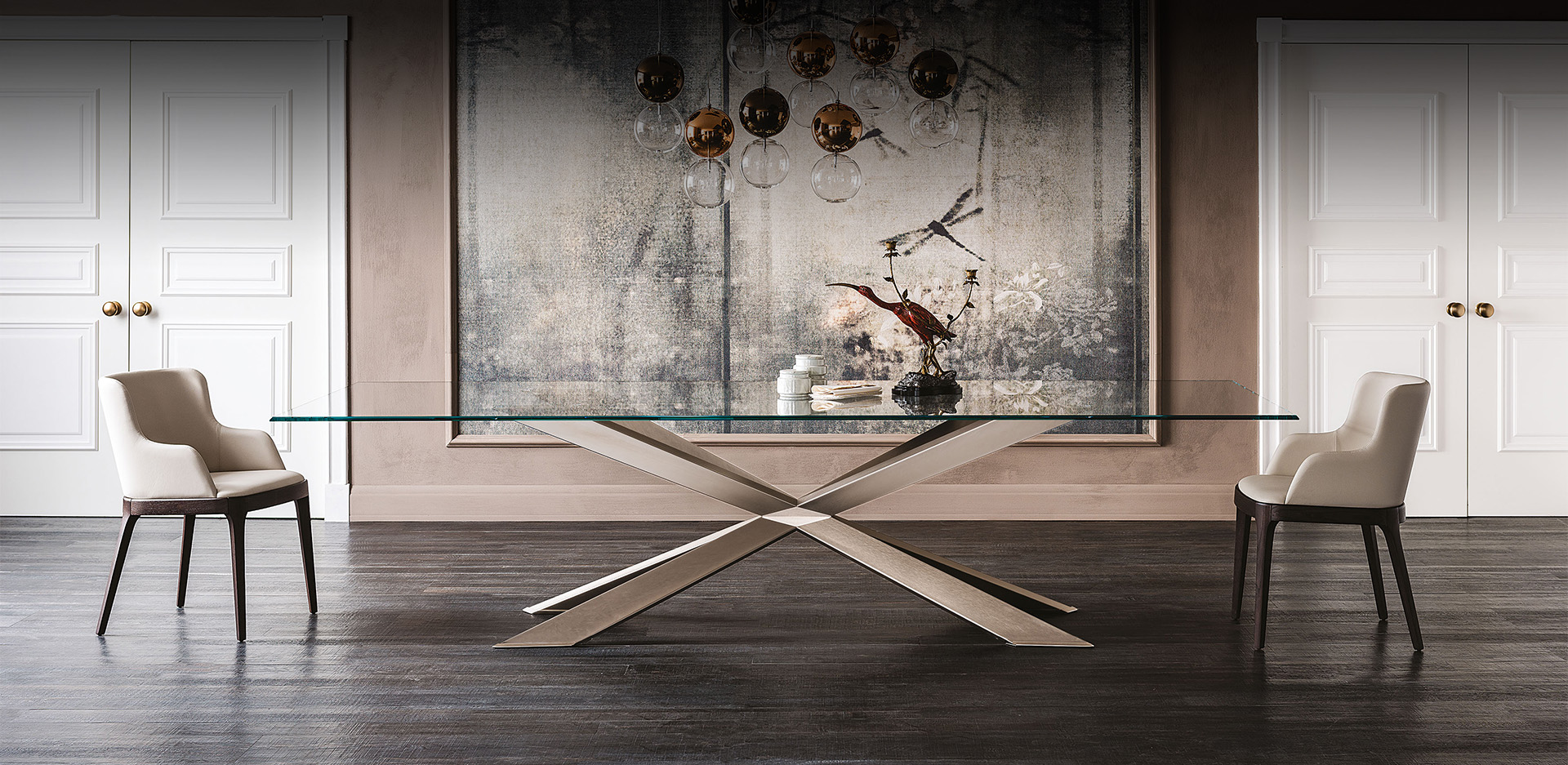 Vista laterale del tavolo Spyder con piano in cristallo trasparente