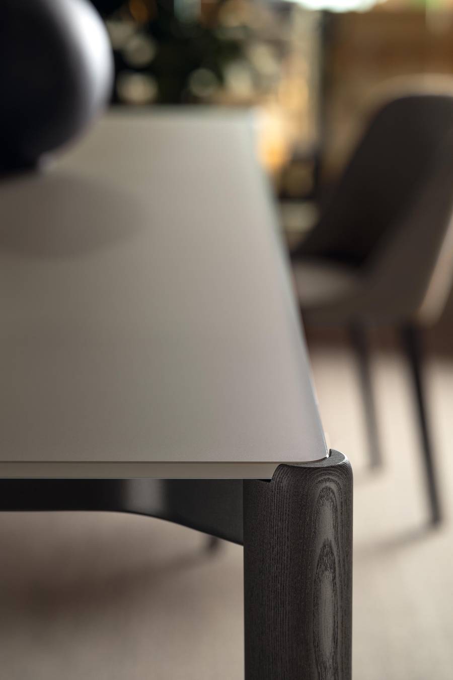 Dettaglio gamba in legno di rovere e piano in vetro del tavolo Correr Slim